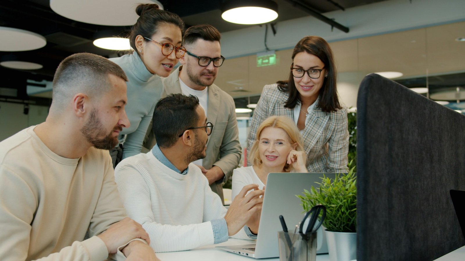 Colleagues from a range of backgrounds reviewing work together at a desk